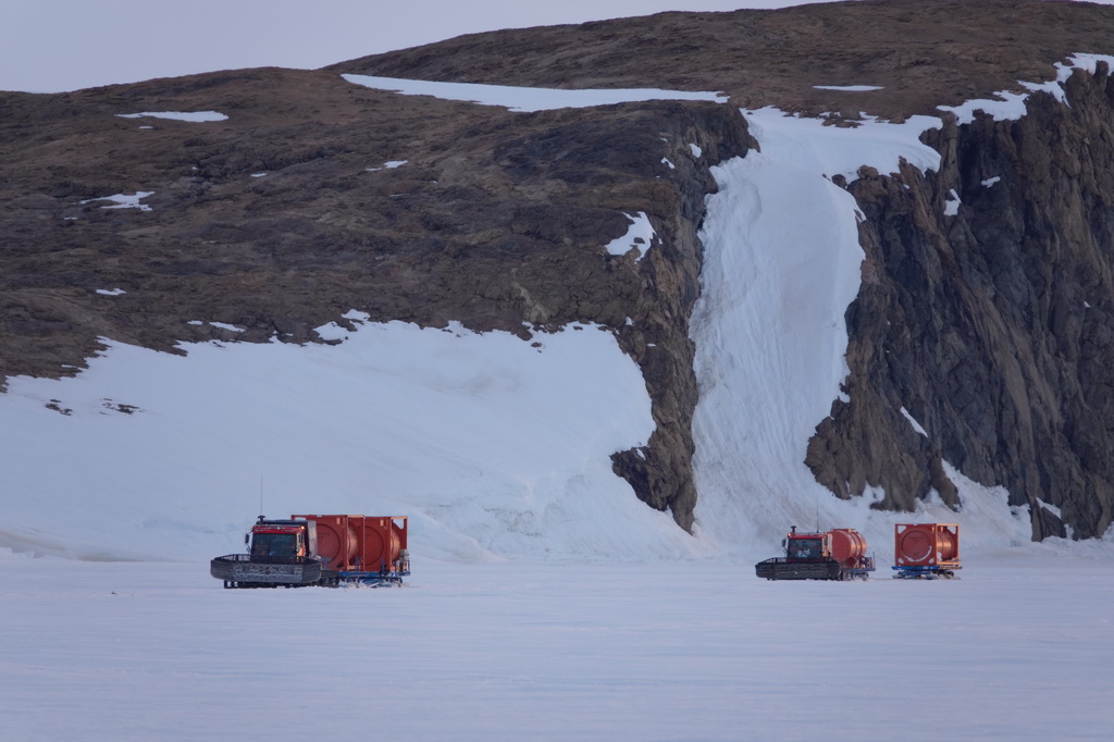 北京时间12月3日凌晨，从中山站和内陆出发基地驶来的雪地车拉着空油罐抵近“雪龙2”号。