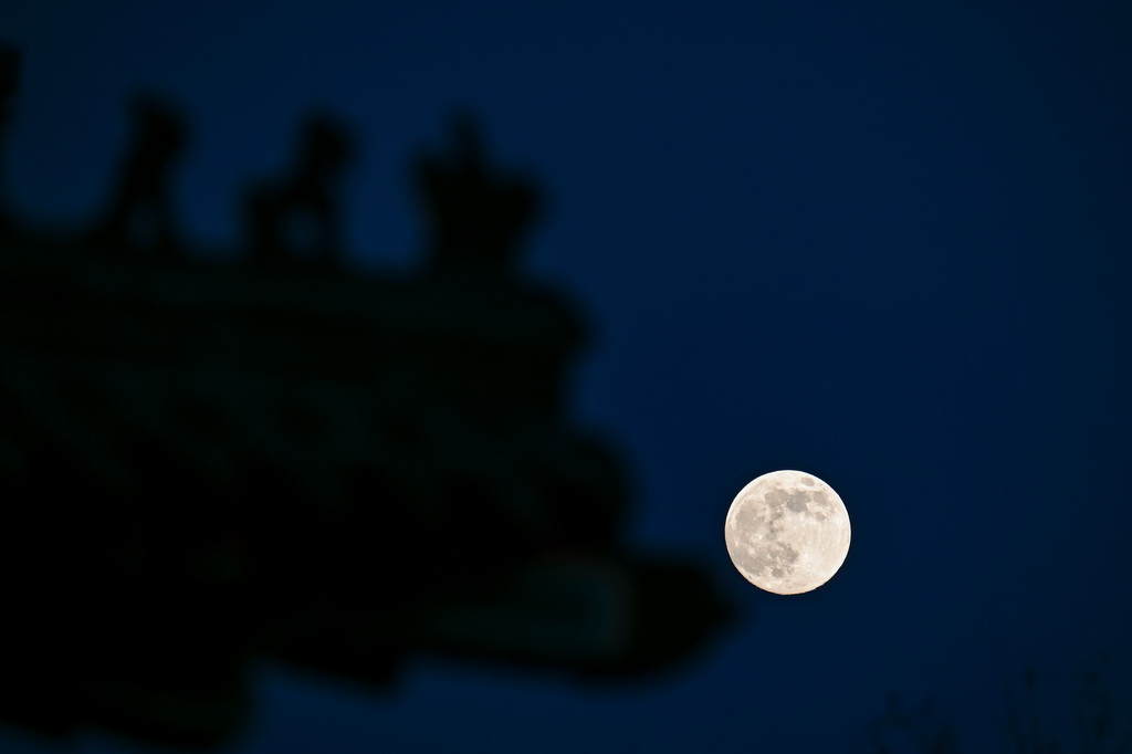 12月4日在北京宣武门附近拍摄的月亮与一处建筑。新华社记者 张铖 摄