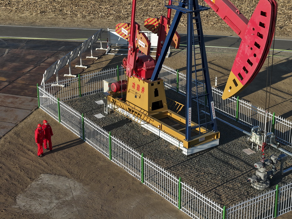 12月4日，在大庆古龙陆相页岩油国家级示范区，中国石油大庆油田第九采油厂页岩油生产运行项目经理部生产操作员对功勋井古页油平1井采油设备开展巡检工作（无人机照片）。