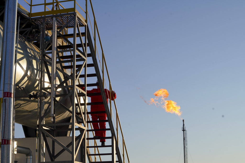 12月4日，在大庆古龙陆相页岩油国家级示范区古页1号站，中国石油大庆油田第九采油厂页岩油生产运行项目经理部生产操作员对站内油气处理设备开展巡检和维护保养工作。