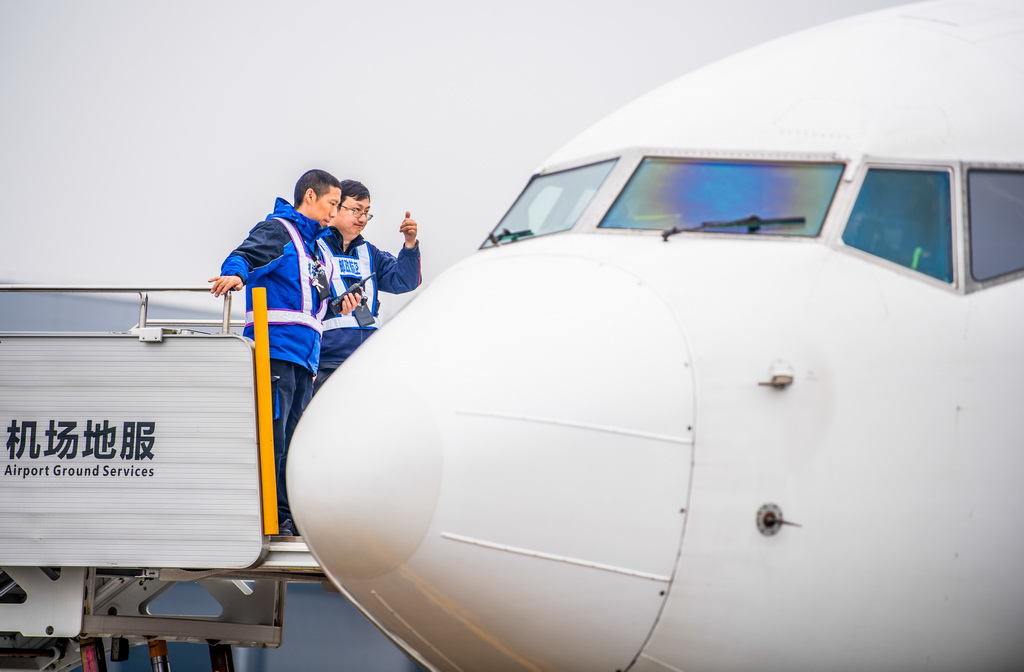 12月9日，工作人员进行中国邮政“重庆至仰光”国际货邮航线首航货机起飞前的准备工作。