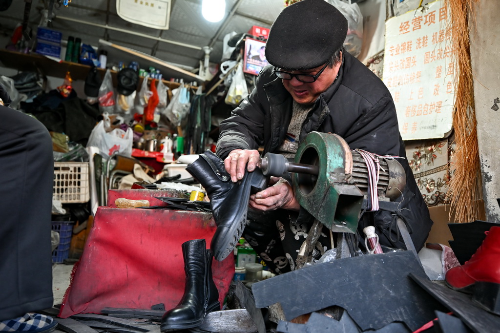 12月9日，商户在为顾客修鞋。新华社记者 张铖 摄