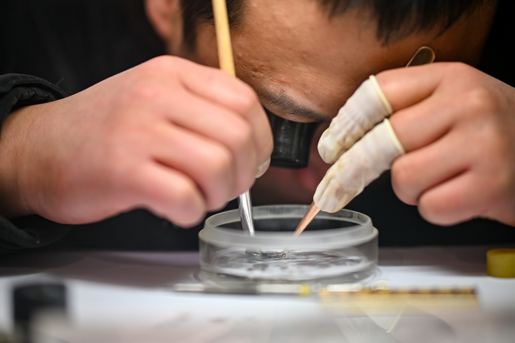 12月9日,商户在清理手表零件。新华社记者 张铖 摄