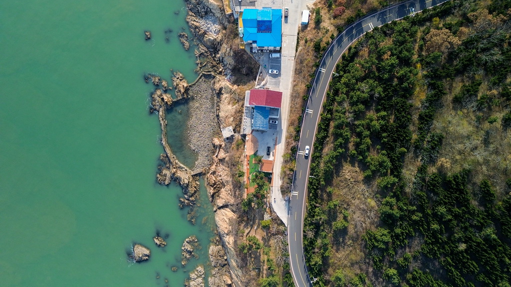 12月9日,车辆在威海市沿海岸线的自驾旅游公路上行驶(无人机照片)。