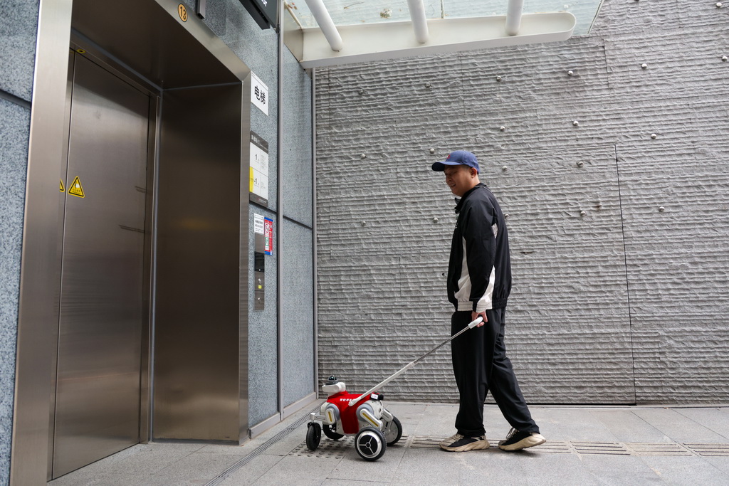 12月13日，在深圳地铁黄木岗交通枢纽，视障乘客体验智能导盲犬。