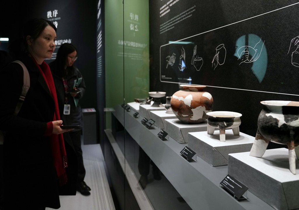 12月12日,参加媒体预览的人员在观看良渚文化陶器。