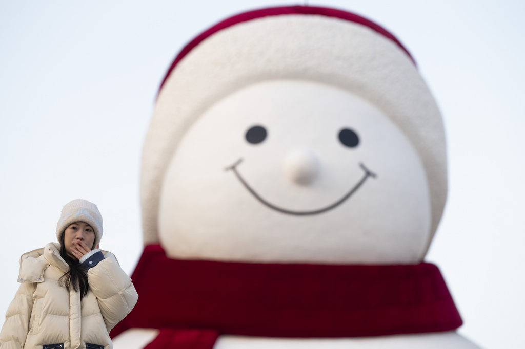 12月15日，游客在哈尔滨市群力音乐公园大雪人前合影。新华社记者 张涛 摄