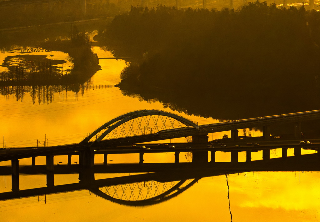 12月16日，一列动车从东湖湖面上空驶过（无人机照片）。新华社记者 肖艺九 摄