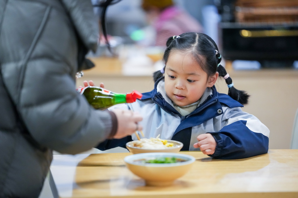 12月12日，在四川省广元市一家凉面馆，小朋友准备吃凉面。新华社记者 连振 摄
