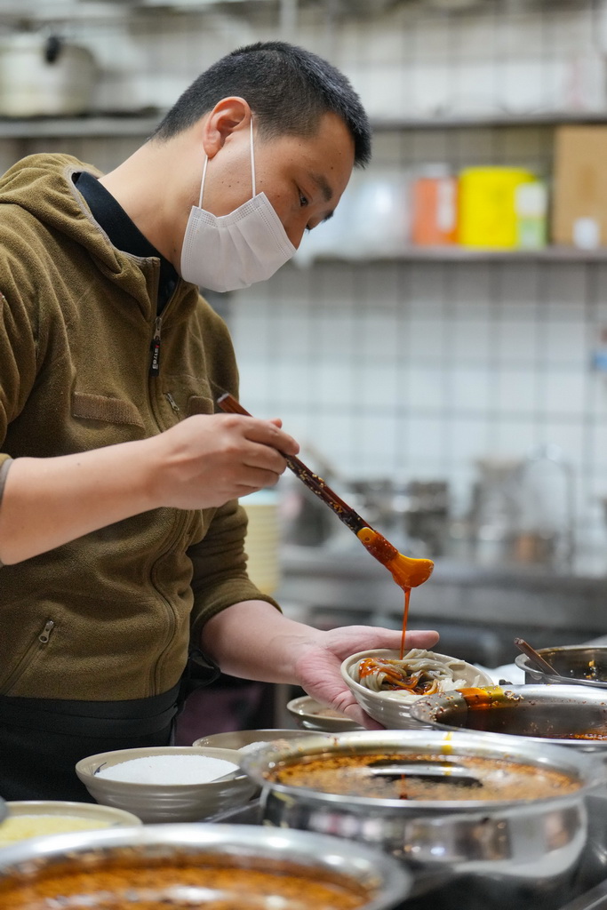 这是12月12日在四川省广元市一家凉面馆，工作人员在调配凉面调料。新华社记者 胥冰洁 摄