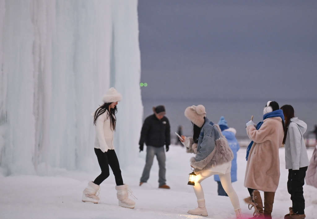 游客在赛里木湖边游玩留影（12月15日摄）。
