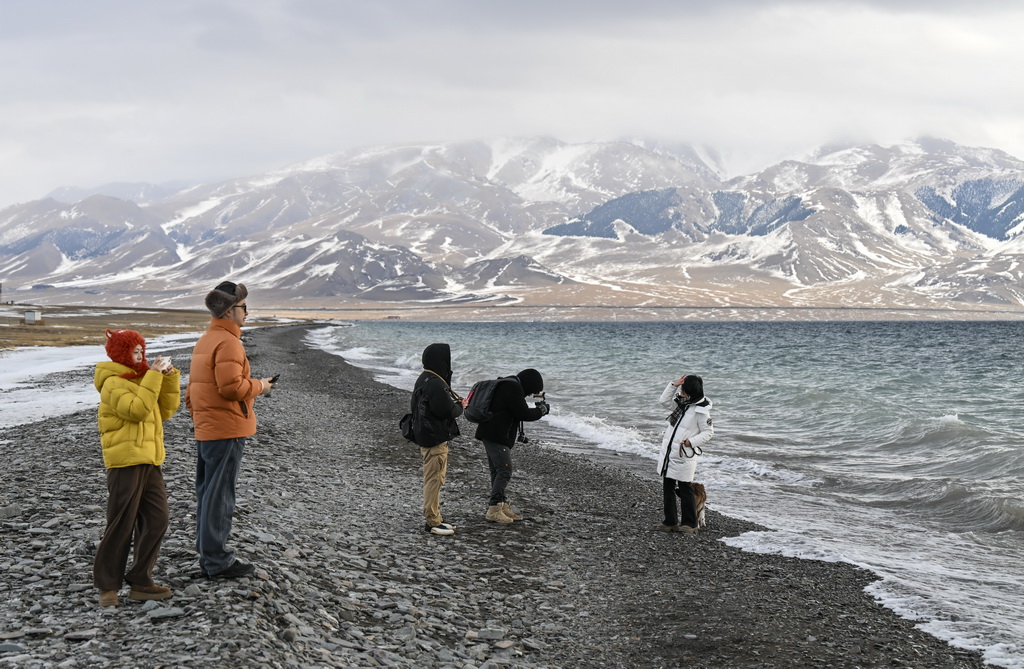 游客在赛里木湖边游玩留影（12月15日摄）。