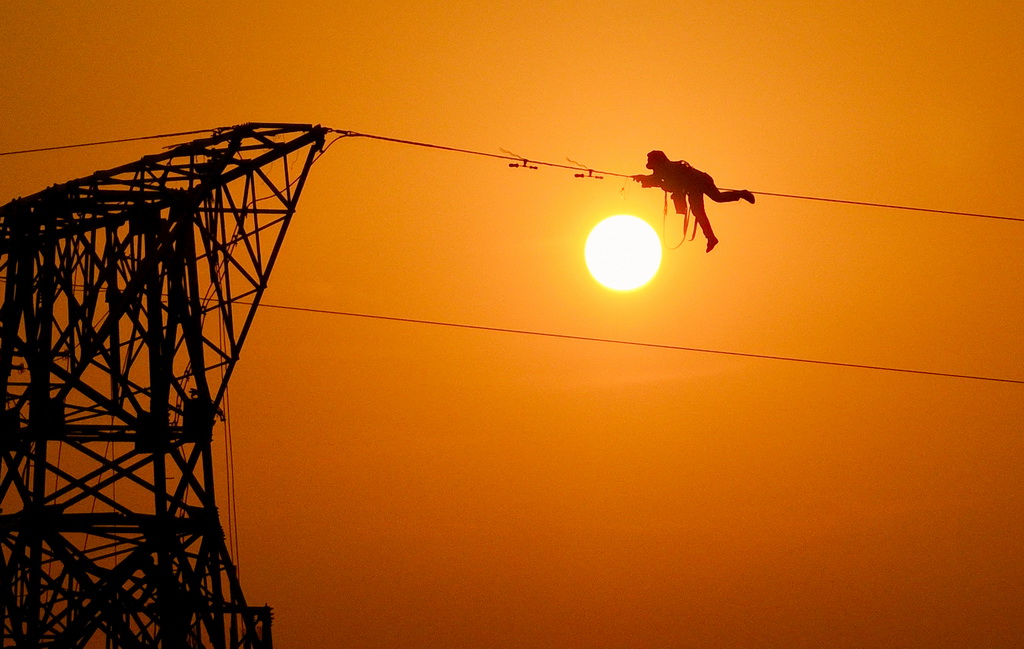 12月16日,施工人员在香涧至鹭岛500千伏线路工程施工现场进行高空作业(无人机照片)。