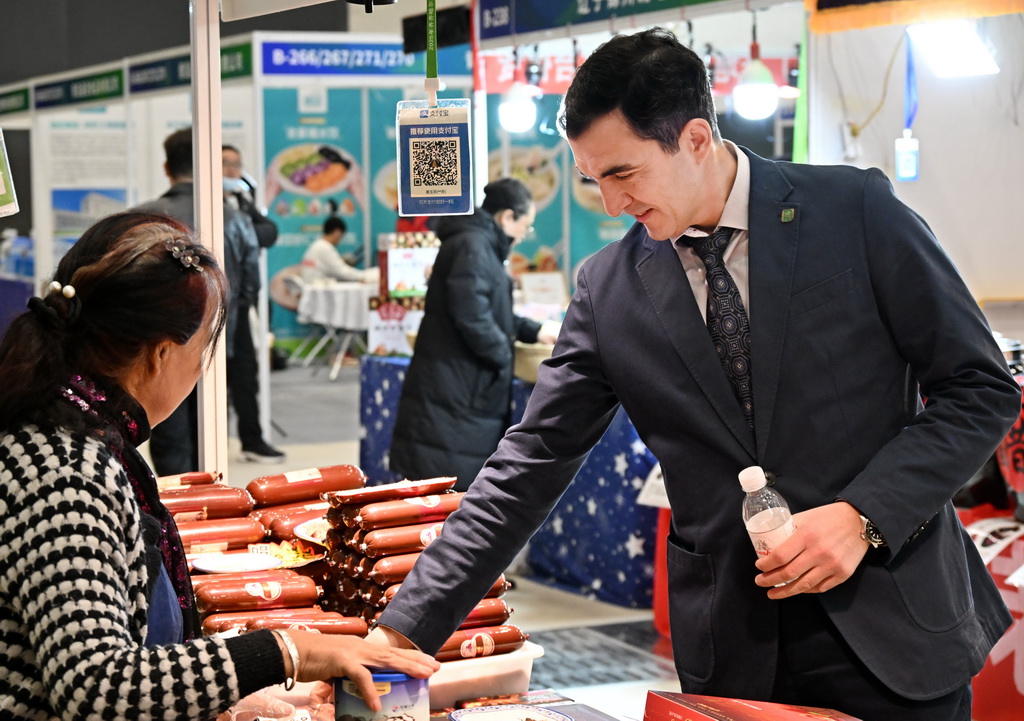 12月19日，一名客商在博览会上了解食材配料。