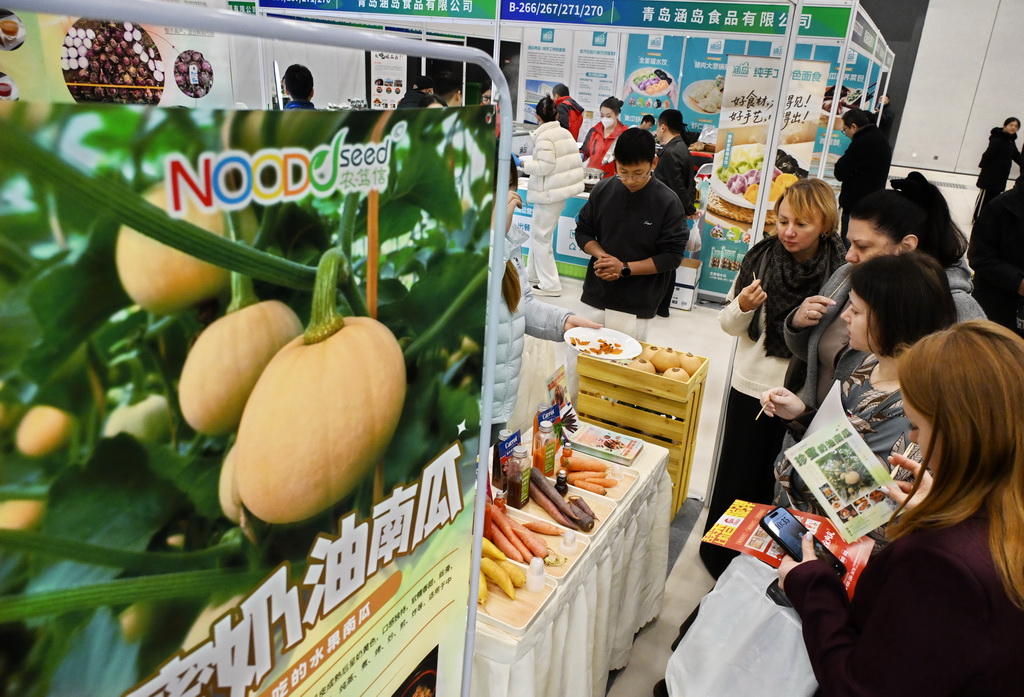 12月19日，客商在博览会一家绿色有机蔬菜展位参观。