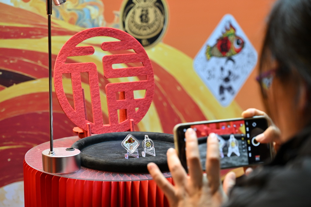12月22日，一名媒体记者在品鉴会上拍摄2026年贺岁金银纪念币。