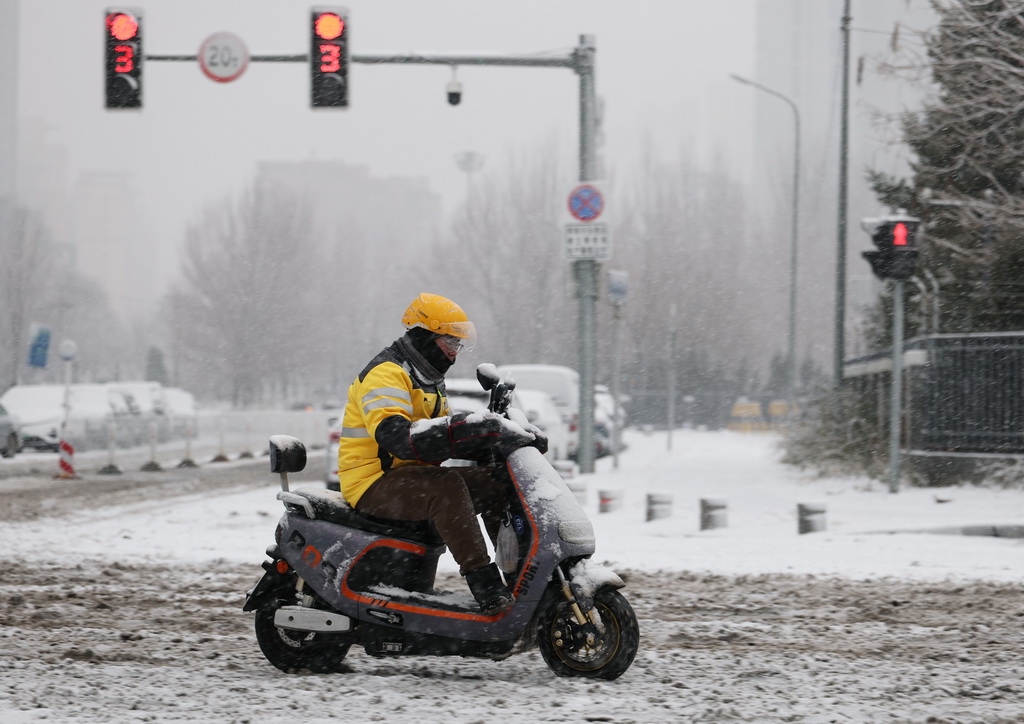 12月23日，一名外卖员冒雪行进在沈阳街头。