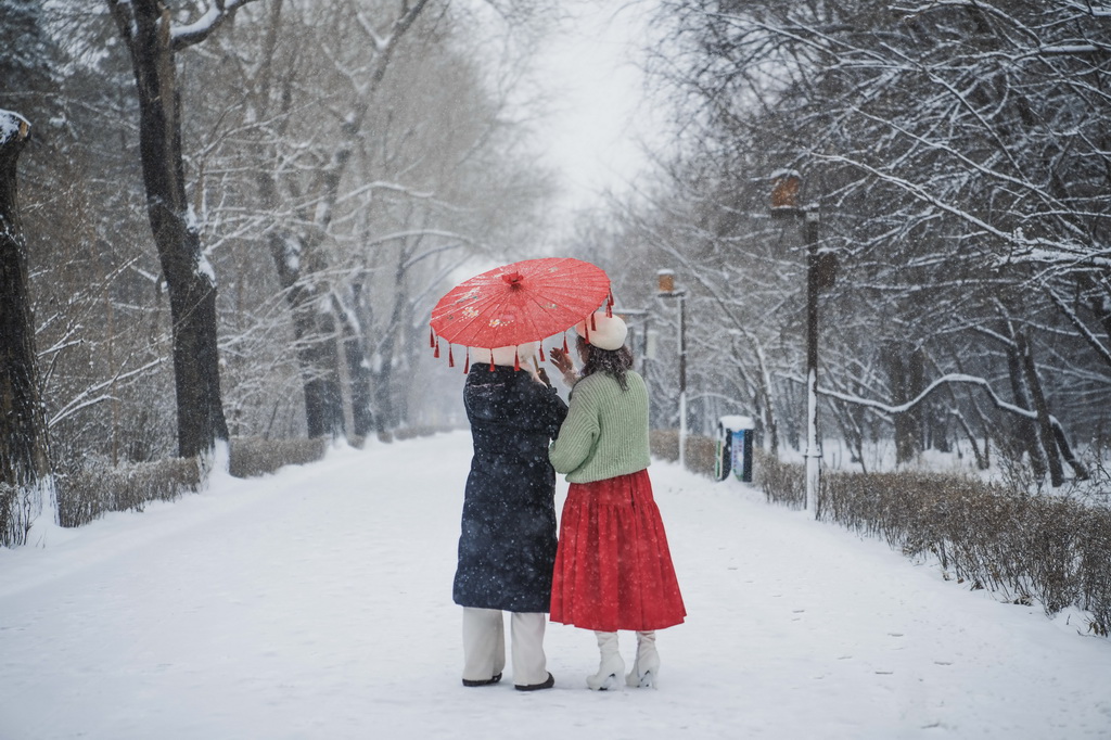 12月23日，市民在长春市南湖公园内观赏雪景。