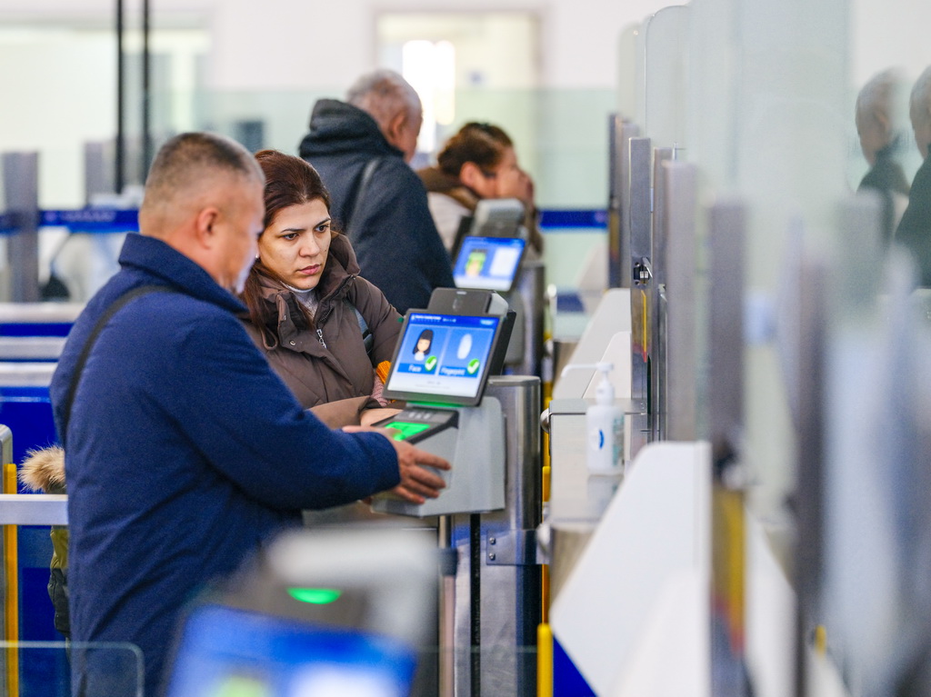 12月24日，在满洲里公路口岸联检大厅，旅客们办理入境手续。