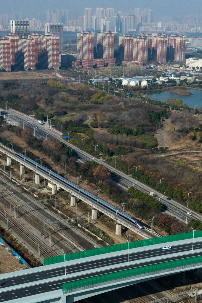 12月28日，列车从武汉古田一路北段下方穿行（无人机照片）。