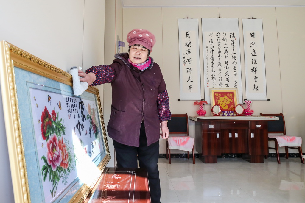 12月29日，村民赵玉真在榆中县马坡乡马莲滩村集中安置点的新家里打扫卫生。