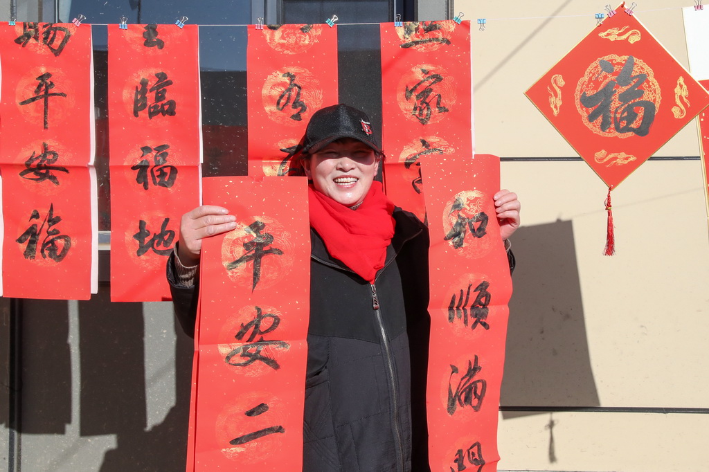 12月29日，村民在榆中县马坡乡马莲滩村灾后重建集中搬迁入住活动现场领取春联。