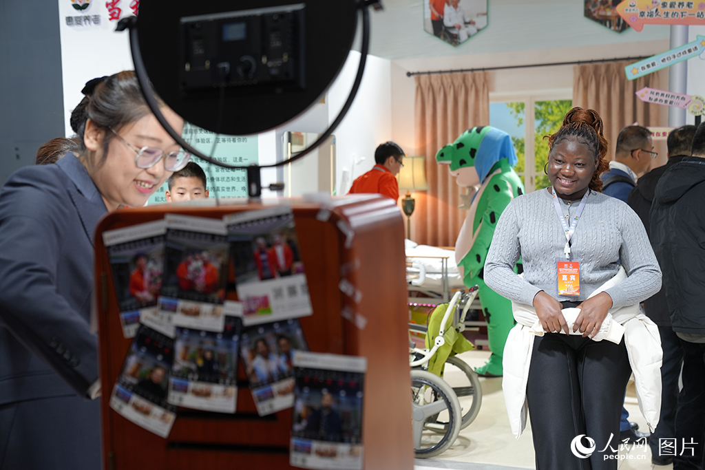 2025年12月7日,在2025长春国际医药健康产业博览会上,一名外国友人在趣味拍照相机前拍照留念。人民网记者 李洋摄