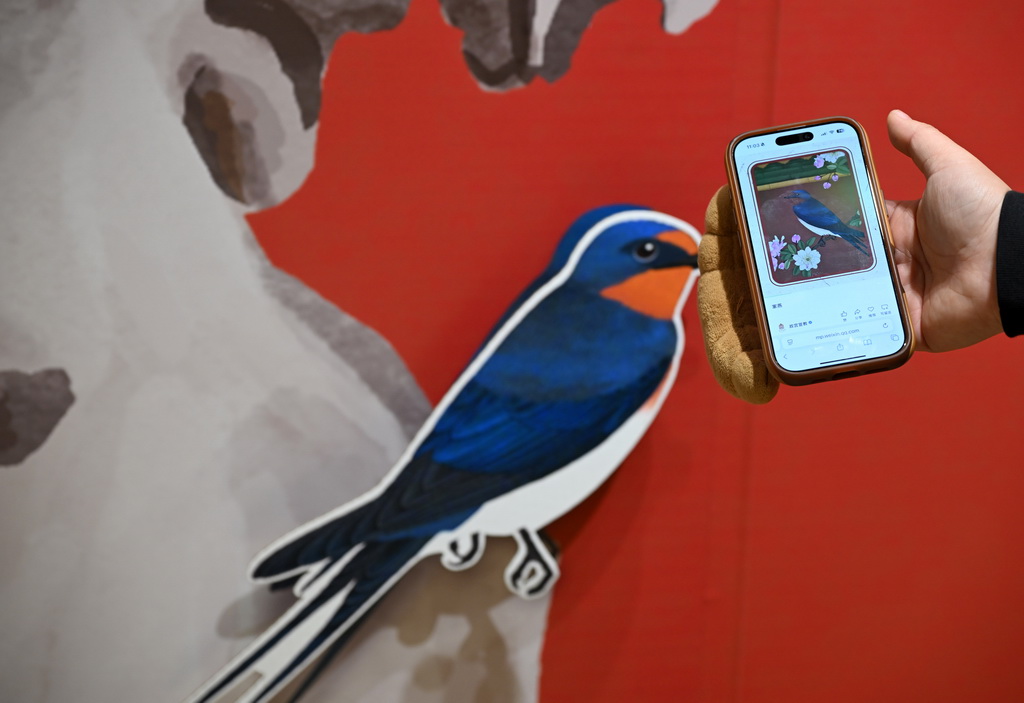 12月30日，观众在“来！听色彩讲故事”故宫教育体验展上用手机参与互动。