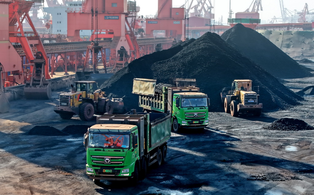 1月5日，在青岛港前湾港区86泊位，工程车辆在进行煤炭转运作业（无人机照片）。