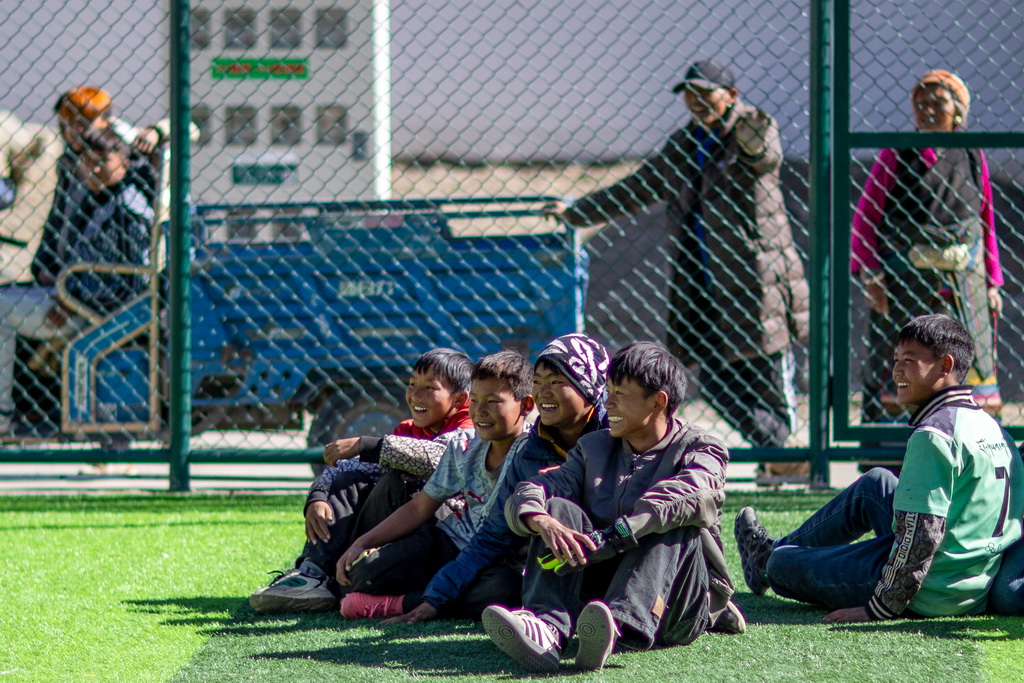 1月5日，在森嘎村的足球场上，少年在观看伙伴们踢球。