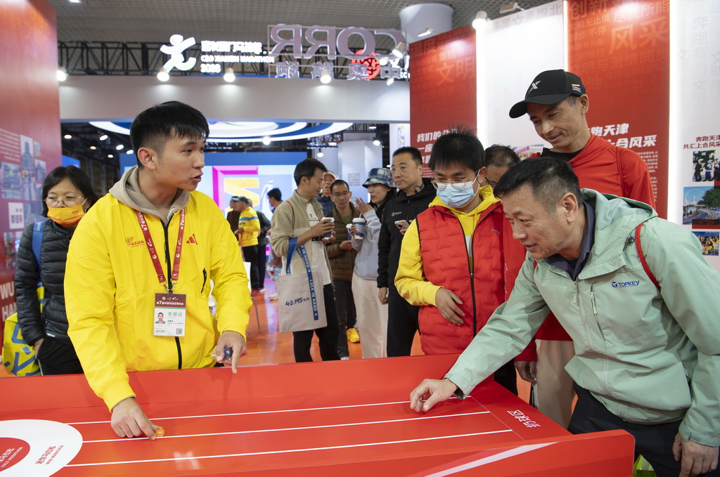 1月8日，厦门马拉松赛选手在博览会现场参加互动游戏。