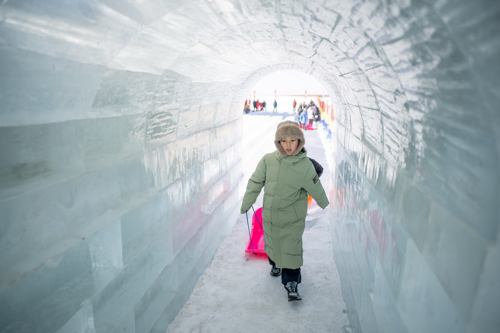 2026年1月10日，一名儿童在呼和浩特哈素海冬捕节上游玩。新华社记者 连振 摄