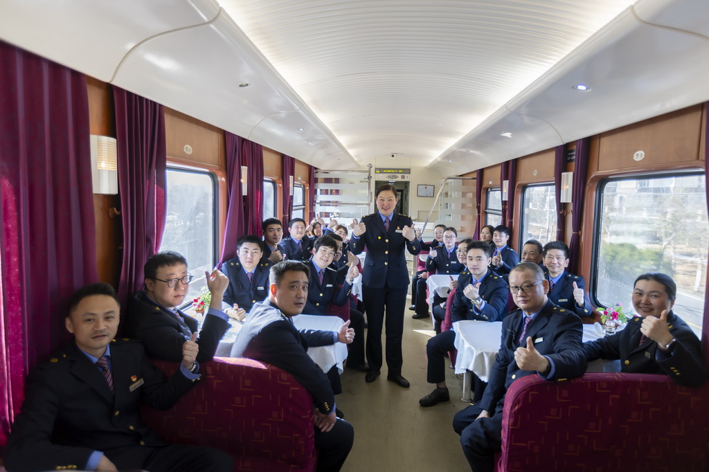 1月14日，中国铁路上海局集团有限公司上海客运段沪港车队列车长李喆（中）和乘务人员在餐车合影留念。