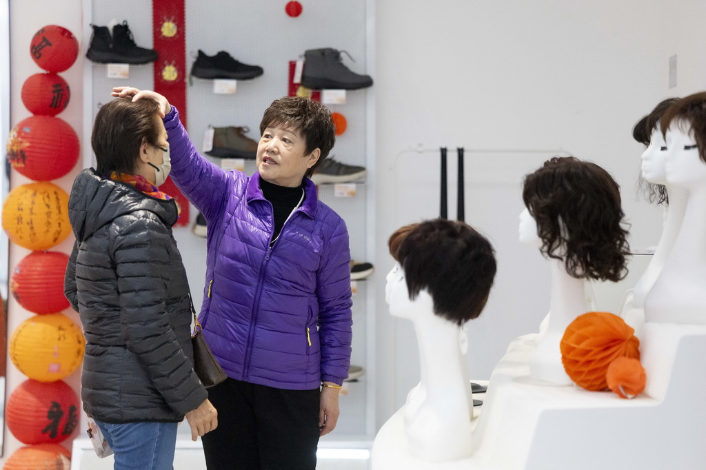 1月15日，上海银发商店的工作人员为顾客推荐假发。