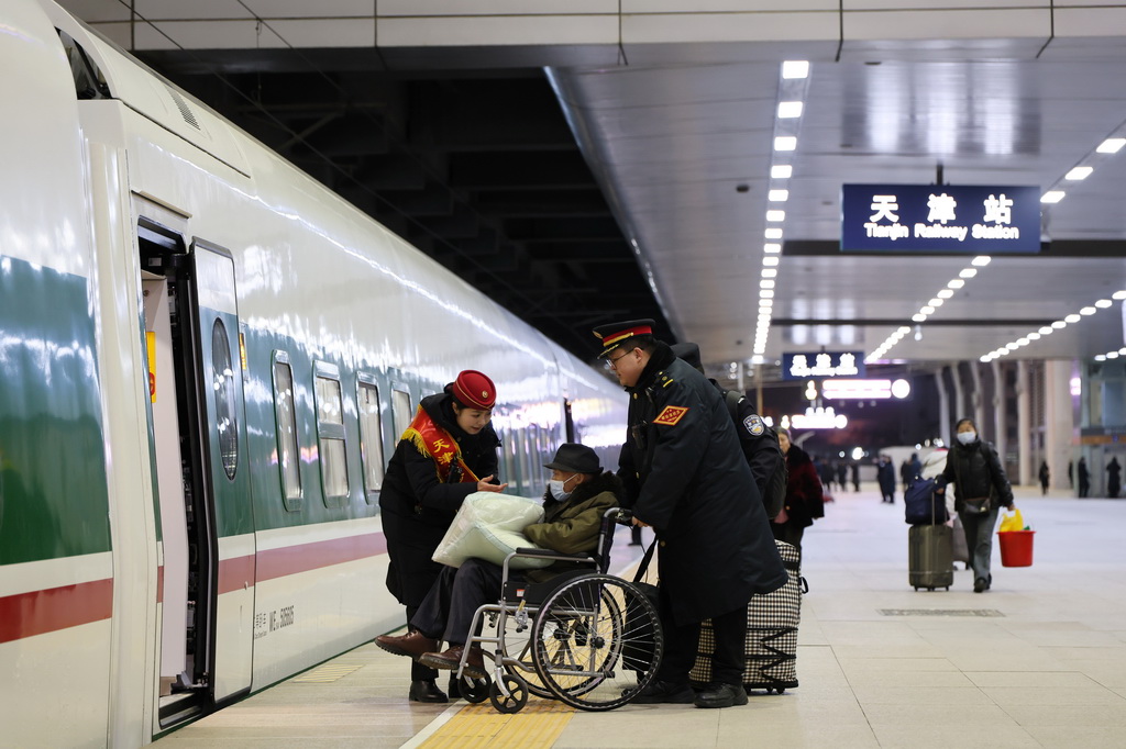 1月19日，铁路工作人员在天津站服务重点旅客上车。