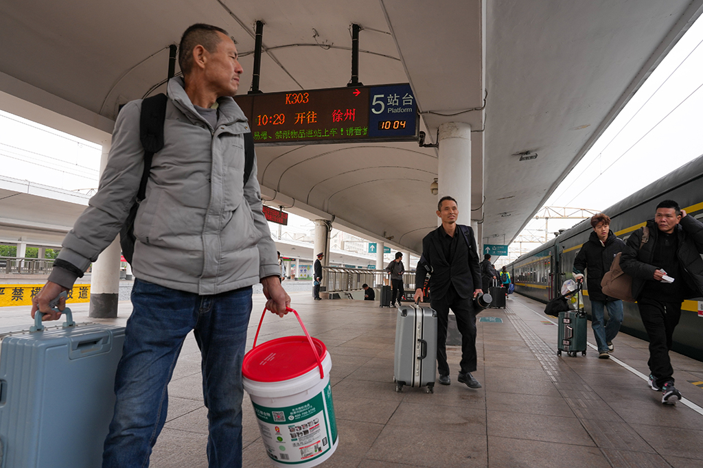 1月25日,在广州火车站,旅客准备登上K303次列车。