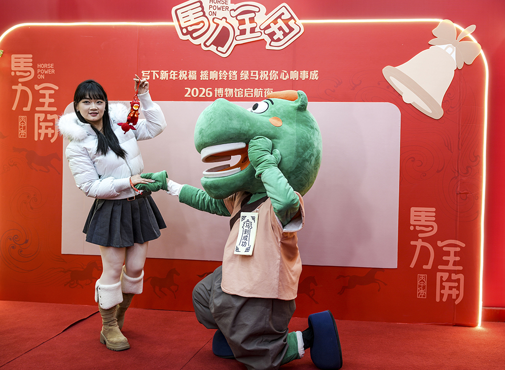 1月26日晚，在甘肃省博物馆一楼大厅，观众与甘博文创马踏飞燕IP人偶互动。