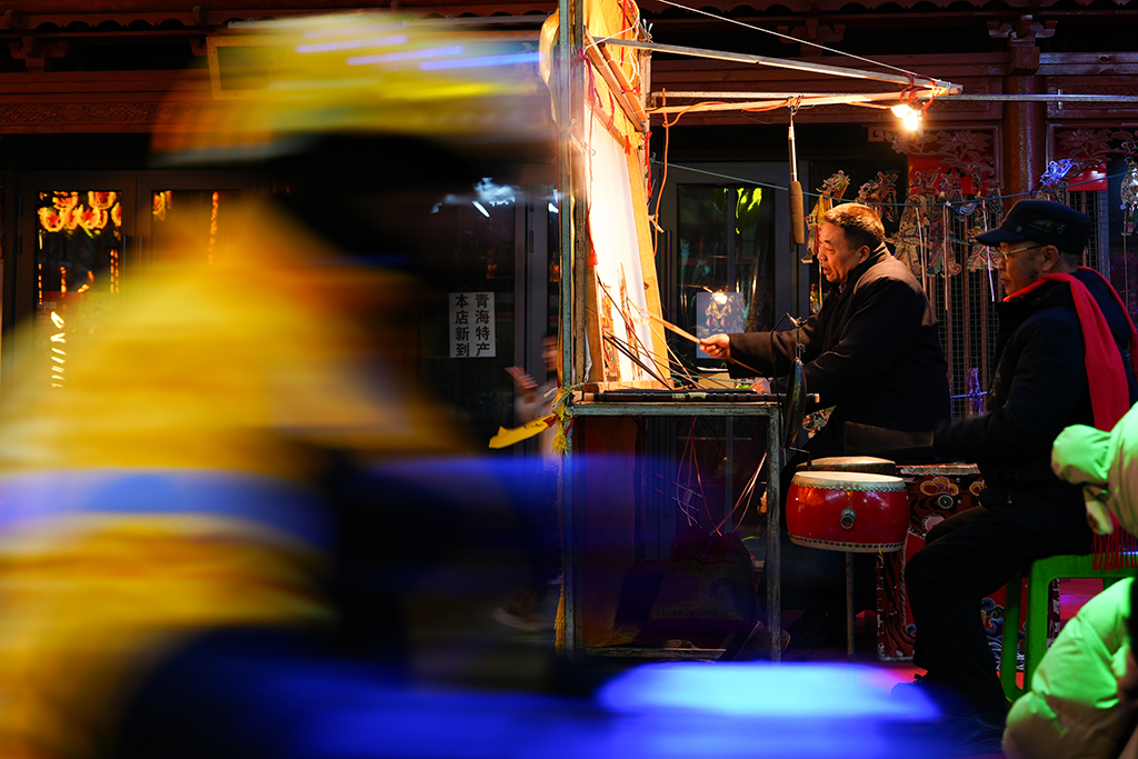 1月25日,周邦辉(右二)在青海省西宁市城北区表演皮影戏。