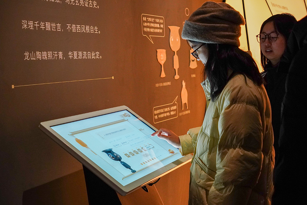 1月27日，观众在山东博物馆参观“对话蛋壳黑陶高柄杯”明星文物展。新华社记者 徐速绘 摄