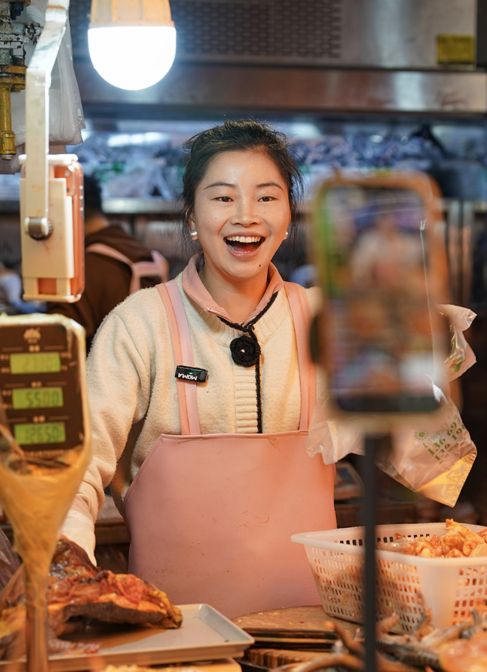 1月27日，一名摊主在昆明大观篆新农贸市场内通过直播方式售卖鸡肉。