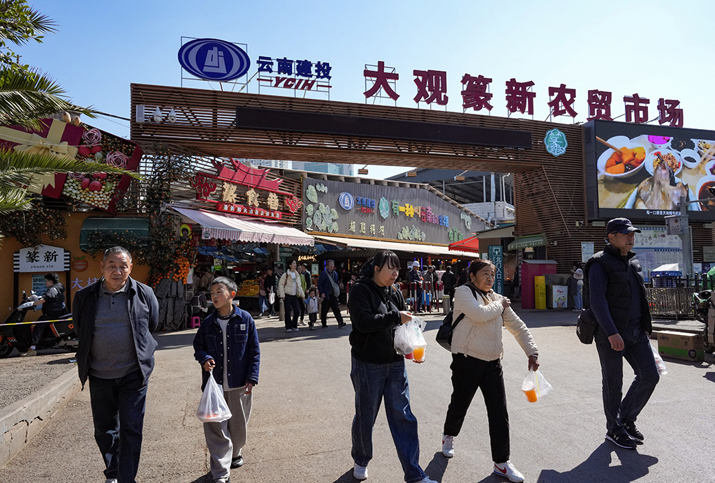 1月27日，人们购物后走出昆明大观篆新农贸市场。