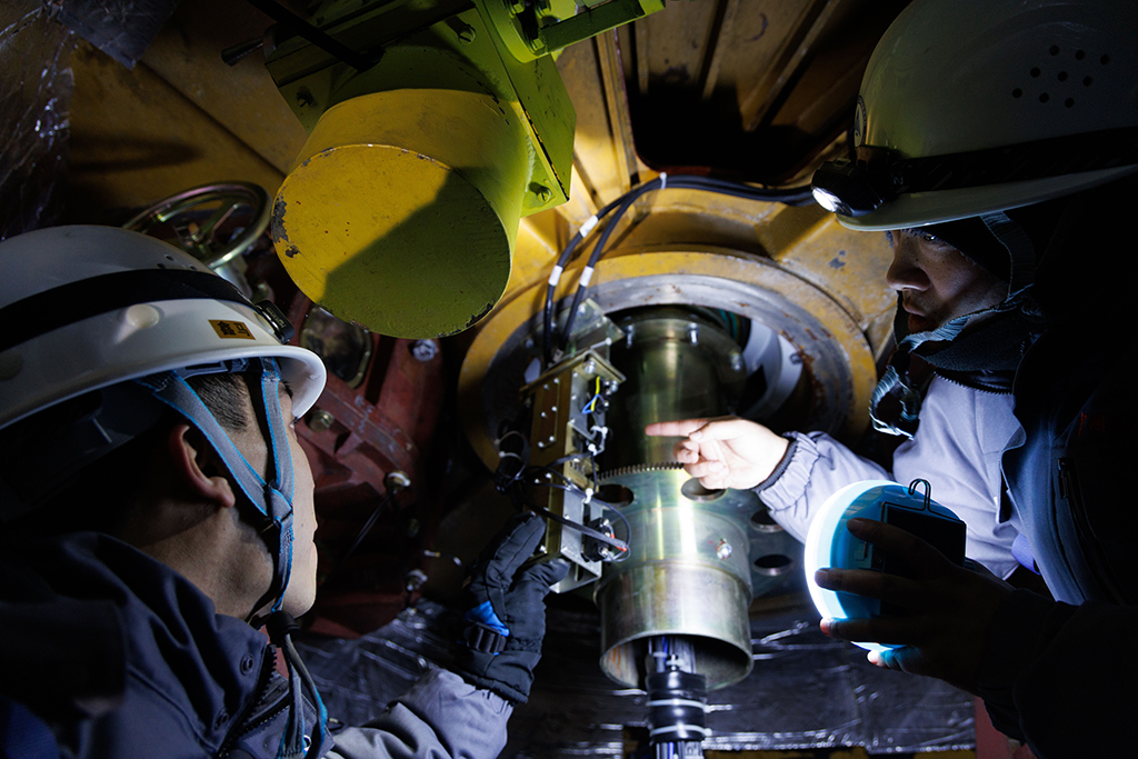 1月24日，工作人员李强（右）和田冬在卫星数据接收系统方位舱进行设备维护。