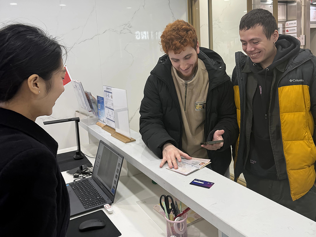 在重庆市渝中区解放碑离境退税集中退付点，来自西班牙的游客（中）在办理退税（1月7日摄）。