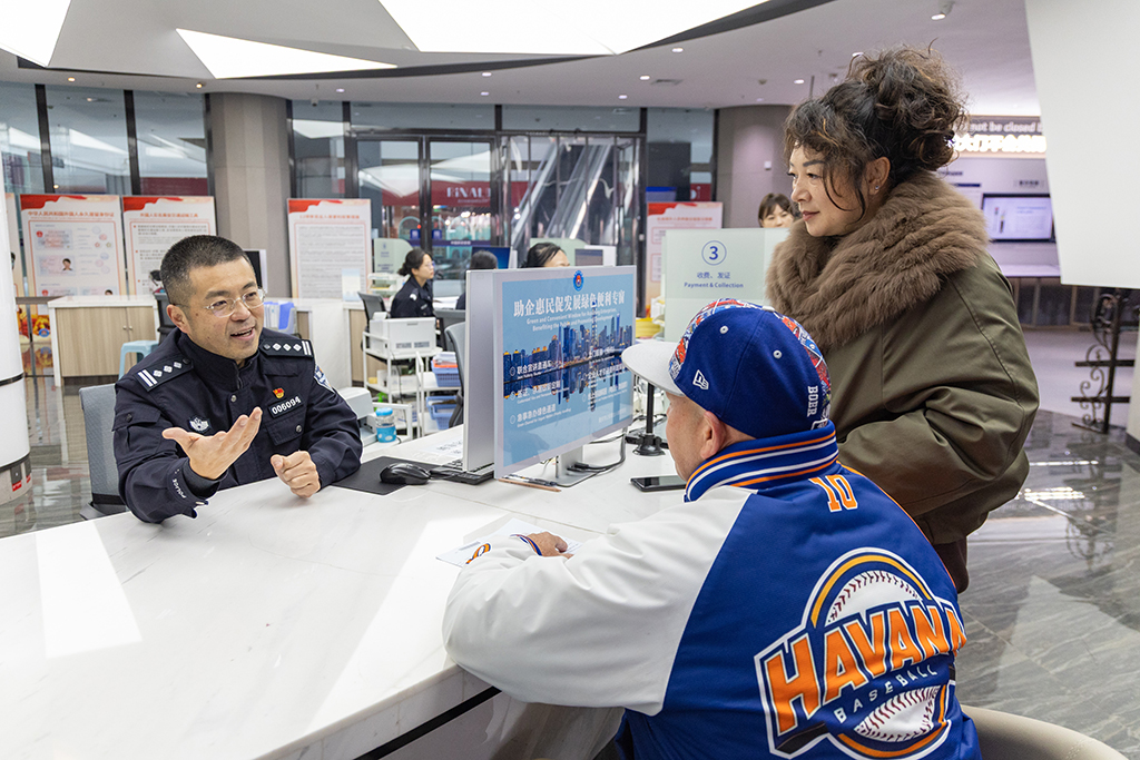 在重庆市公安局出入境管理局移民事务服务中心，民警为外籍人员解答相关永居政策（1月27日摄）。