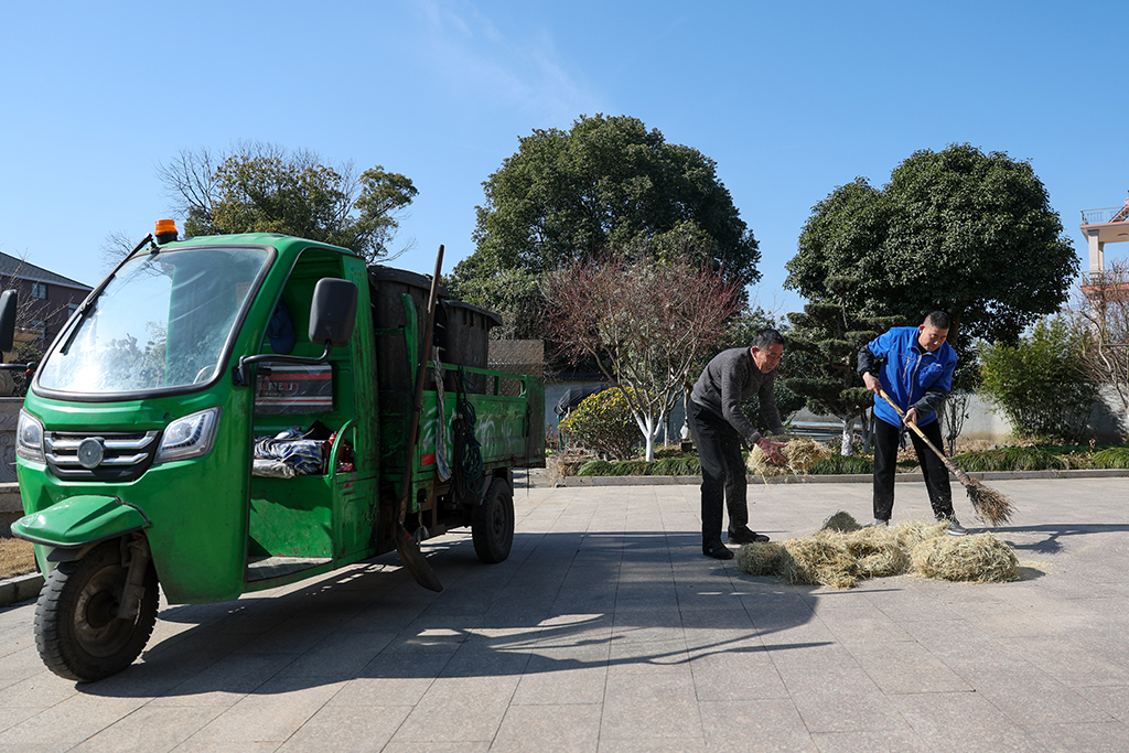 2026年1月14日,在浙江省杭州市余杭区普宁村,工作人员(右)来到村民家中回收垃圾。新华社记者 江汉 摄