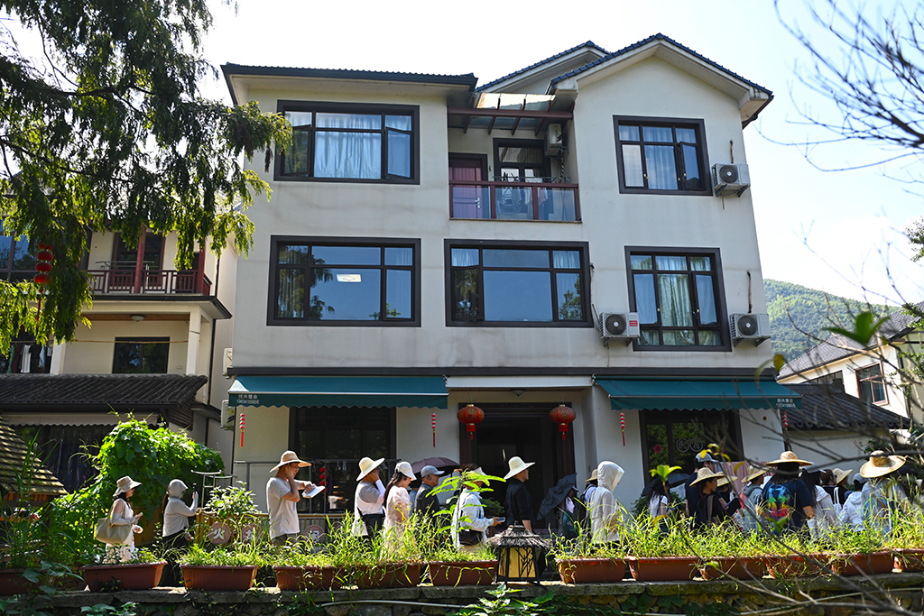 2025年8月5日,在浙江省杭州市余杭区径山村,游客经过一家低碳民宿。新华社记者 毛竹 摄