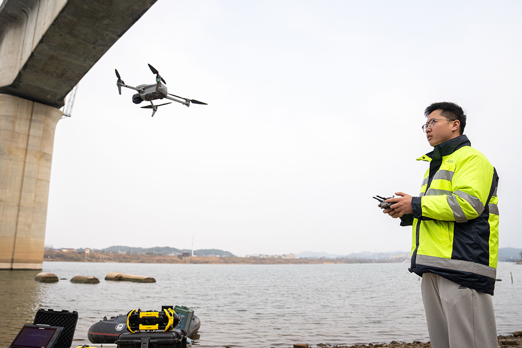 1月29日，在沪昆高铁湘江特大桥下，铁路工人操作无人机准备检测铁路桥墩上部结构外观。