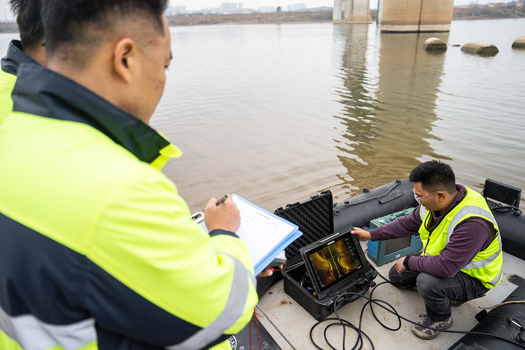 1月29日，在沪昆高铁湘江特大桥下，铁路工人在记录声呐检测系统反馈回来的画面及数据。