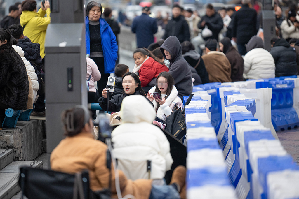 1月21日,在重庆市网红地标洪崖洞,主播在滨江路边架设设备直播。新华社记者 唐奕 摄