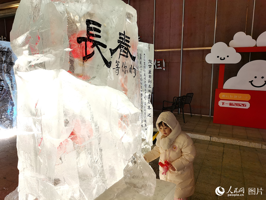 2026年1月26日，在吉林省长春市春京西历史文化街区，游玩的小朋友对晶莹剔透的冰雕充满了好奇，此刻冰雪不再是冬日的静态景致，而是化作可触摸、可感知的文化载体。人民网记者 王帝元摄